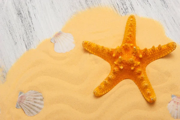 Fondo de madera gris con arena amarilla y estrella de mar naranja — Foto de Stock