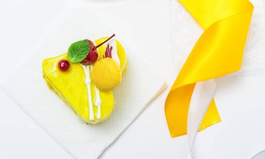 lemon yellow heart cake with cherries and cream with yellow ribbon