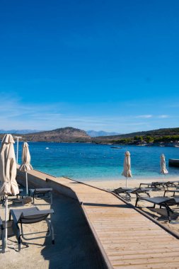 Arnavutluk 'un Ksamil kentinde sabah kumsalında şemsiyeler ve şezlonglar