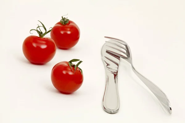 Tomatoes, knife and fork — Stock Photo, Image