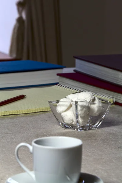 Un pequeño jarrón con caramelos, cuaderno y libros — Foto de Stock