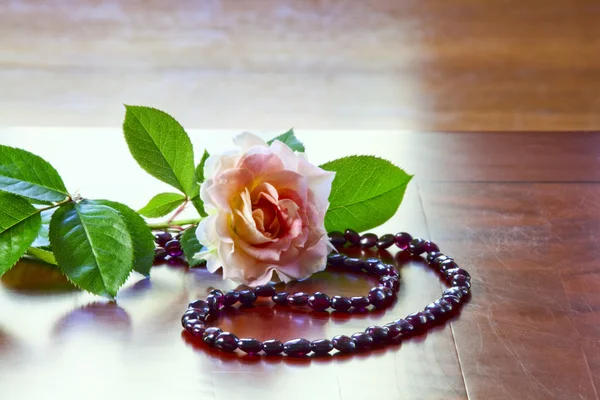 Гранатовое ожерелье и роза — стоковое фото