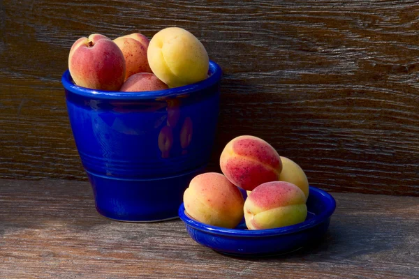 Pitcher and bowl with apricots — Stock Photo, Image