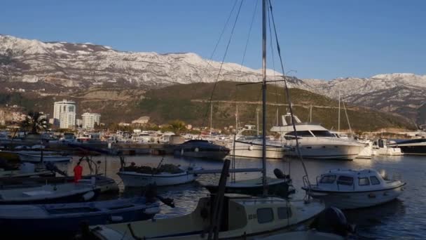 Wharf met afgemeerde boten tegen de achtergrond van bergen in de sneeuw — Stockvideo