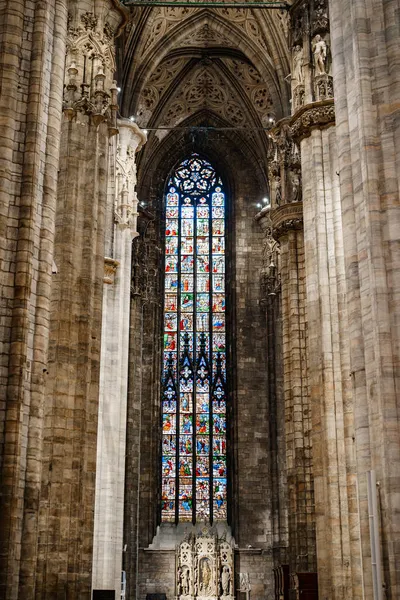 Barevné vitrážní okno proti sloupům a klenutý strop v Duomo. Itálie, Milan — Stock fotografie