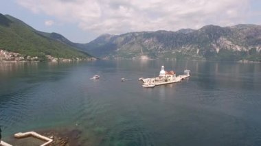 Uzun selvi ağaçları ve St. Georges Adası manastırının havadan görünüşü.