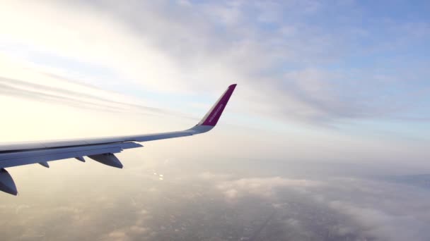 Ala de um avião voador contra o fundo de um céu azul brilhante — Vídeo de Stock