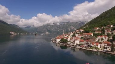 Dağların eteğinde kırmızı kiremitli çatıları olan evler. Perast, Karadağ