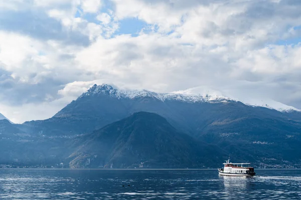 Färjan flyter på sjön mot bakgrund av bergen. Italien, Como — Stockfoto
