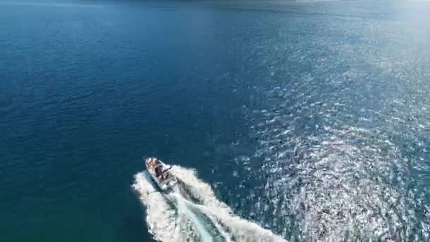 Bateau à moteur navigue le long de la baie de Kotor sur fond d'îles près de Perast — Video