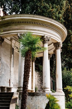 Bahçesinde sütunları olan yuvarlak mermer bir çardak. Villa Manastırı, Como, İtalya