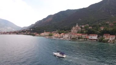 Motorlu yat Kotor Körfezi boyunca Prcanj sahilini geçerek yol alıyor.