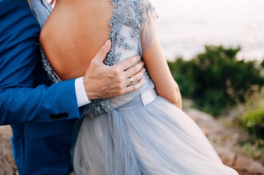 Damat elini gelinin sırtına koydu. Denize yakın sahilde duruyordu. Kapat.