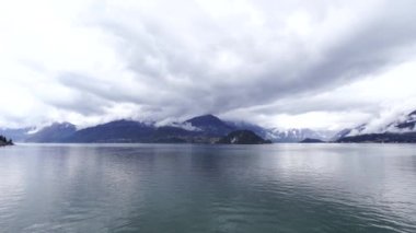 Dağların üzerinde beyaz alçak bulutlar. Como Gölü, İtalya