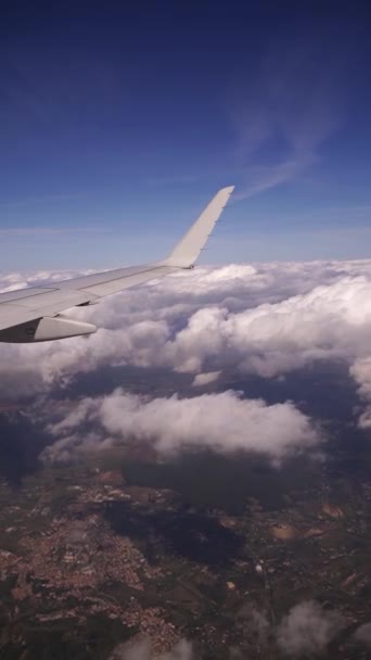 Uitzicht vanuit de patrijspoort van de stad door witte wolken — Stockvideo