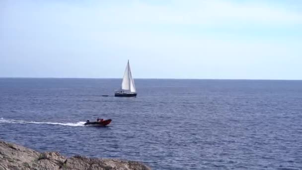 Motorboot en een zeilboot varen op de Kotor baai — Stockvideo