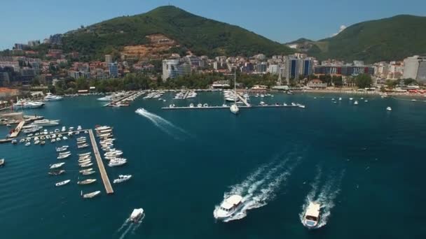 Plezierboten drijven op de achtergrond van de pieren voor de kust van Budva — Stockvideo