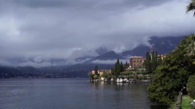 Varenna kıyısı boyunca arka planda dağlar olan evler. Como Gölü, İtalya