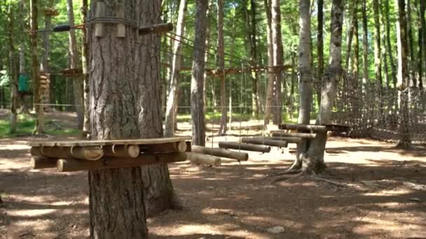 Äventyrspark med cirkelgrunder, trappor, rep och gångvägar i skogen — Stockvideo