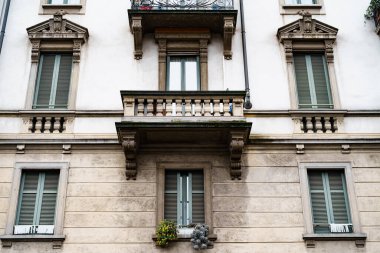 Binanın ön cephesinde balyalarla oyulmuş taş balkonlar. Milan, İtalya