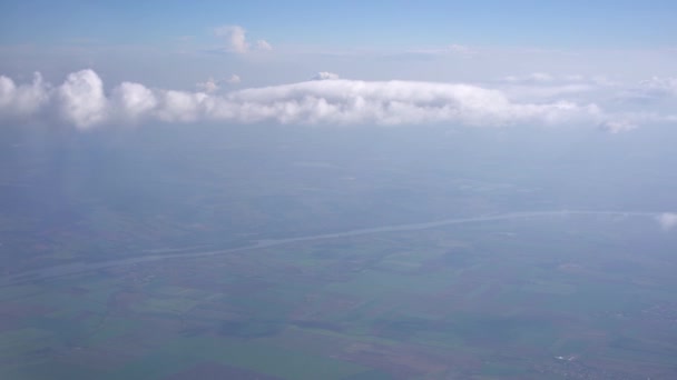 Vue des terres agricoles depuis la fenêtre de l'avion à travers les nuages blancs — Video