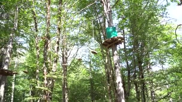 Пригодницький парк з круглими майданчиками і мотузками на деревах — стокове відео