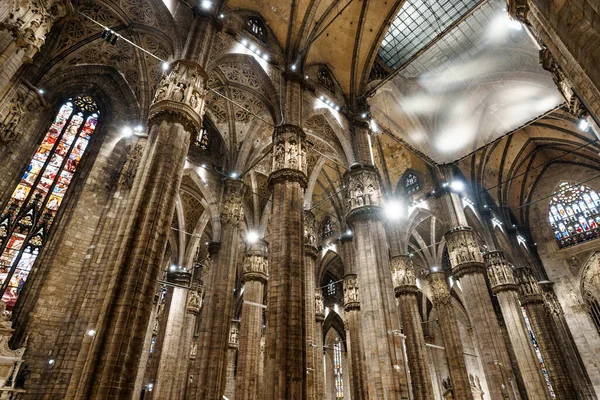Hohe geschnitzte Säulen unter der beleuchteten Decke im Dom. Italien, Mailand — Stockfoto