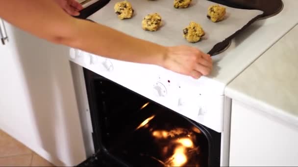 Ragazza mette in forno una teglia con biscotti americani con gocce di cioccolato — Video Stock