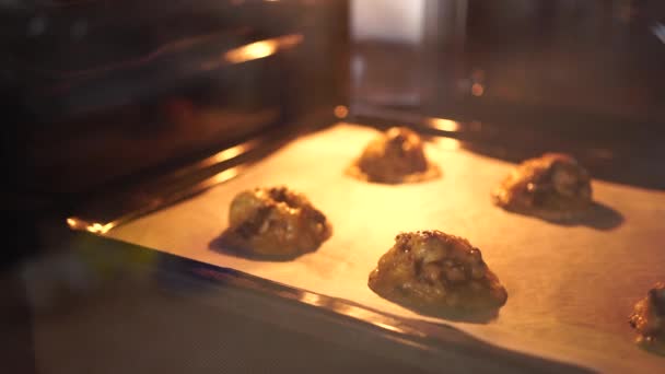 Amerikaanse chocolade chip koekjes verspreid wanneer gebakken in de oven — Stockvideo