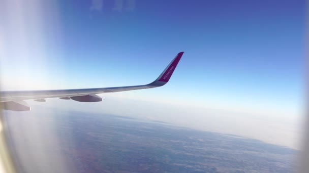 Uçağın kanadındaki pencere deliğinden gökyüzünün arka planına bak — Stok video