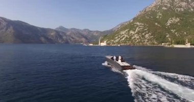 Yeşil dağ ve adaların arka planına karşı yelkenli yelken açar