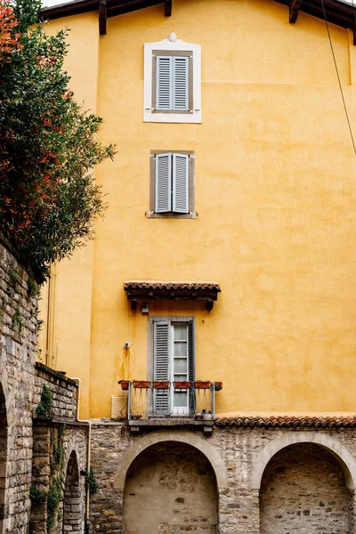Orangefarbene Fassade eines alten Hauses mit Bögen. Bergamo, Italien — Stockfoto