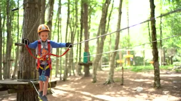 男孩在冒险公园的绳索空中小径上行走 — 图库视频影像