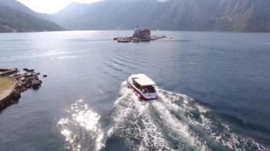 Turist gemisi Kotor Körfezi 'nden geçiyor. St. George adasını geçip Gospa od Skrpjela' ya gidiyor.