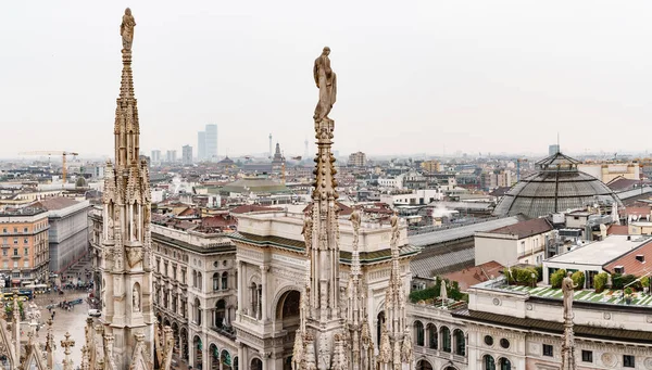 Статуи на шпилях Дуомо на фоне города. Милан, Италия — стоковое фото