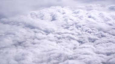 Uçak penceresinin dışında beyaz kümülüs bulutları