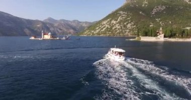 Beyaz motorlu tekne St. George adalarını geçerek denizde yüzüyor.