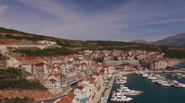 Marina köyünün setinde demirlemiş yatları olan çatılar dolusu ev.