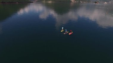 SUP sörfçüleri Kotor Körfezi boyunca yelken açarlar. Perast, Karadağ