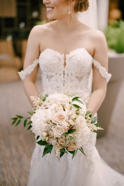 Sposa con un mazzo di fiori è in piedi in casa — Foto Stock