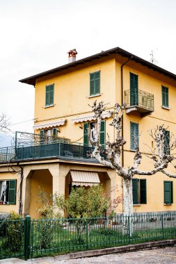 Varenna şehrinin pencerelerinde terası ve panjuru olan eski bir ev. Como, İtalya