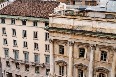 Balkonlarında sütunları ve balkonu olan eski bir binanın ön cephesi. Milan, İtalya