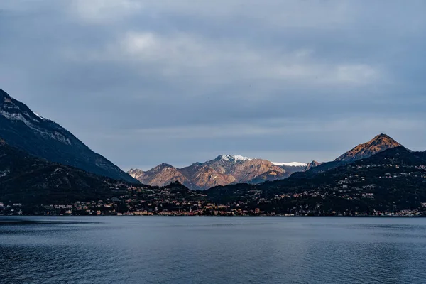 Snötäckta toppar i en bergskedja i solstrålar. Comosjön. Italien — Stockfoto