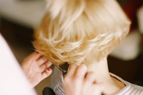 Parrucchiere riccioli le ragazze capelli corti con un ferro arricciacapelli. Primo piano. Vista posteriore — Foto Stock