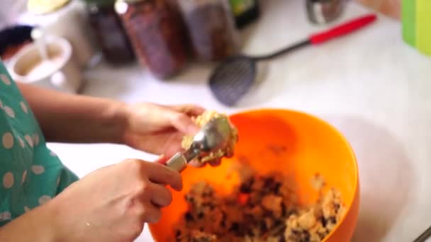 Mujer esculpe galletas de chocolate americano con una cuchara y se acuesta en una bandeja para hornear — Vídeos de Stock