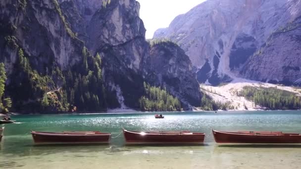 Lodě stojí na břehu jezera Lago di Braies na pozadí hor. Itálie — Stock video
