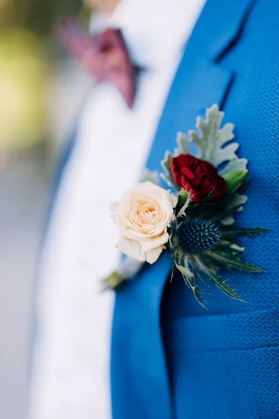Groom in a blue suit with a burgundy bow tie and boutonniere. Close-up — Stock Photo, Image
