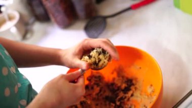 Kadın, Amerikan çikolatalı kurabiyelerini elleriyle yontuyor.