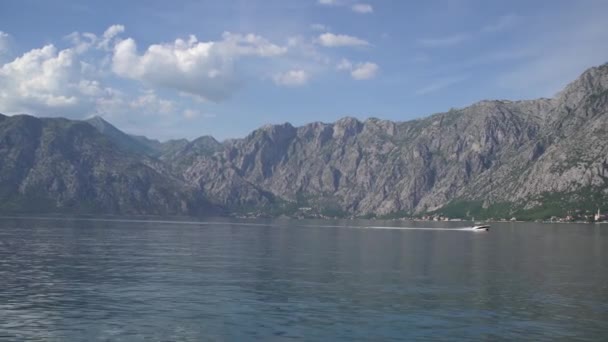 Bateau à moteur navigue le long de la baie de Kotor sur fond de montagnes — Video