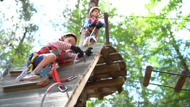 小さな男の子は、キャビナーを再配置することによって登山壁に登る — ストック動画